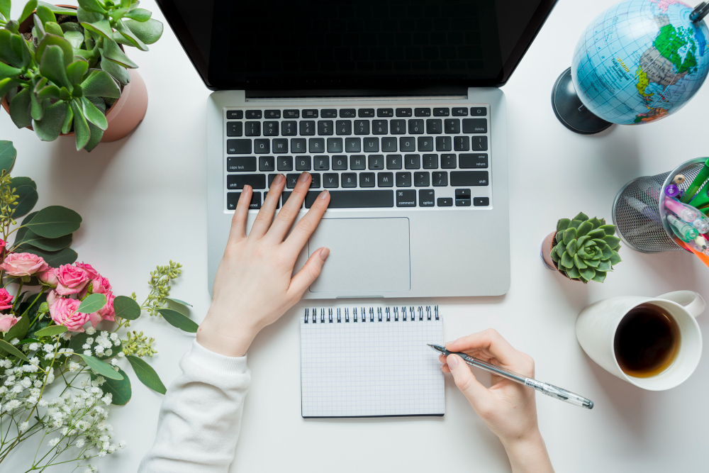 crop-hands-making-notes-using-laptop